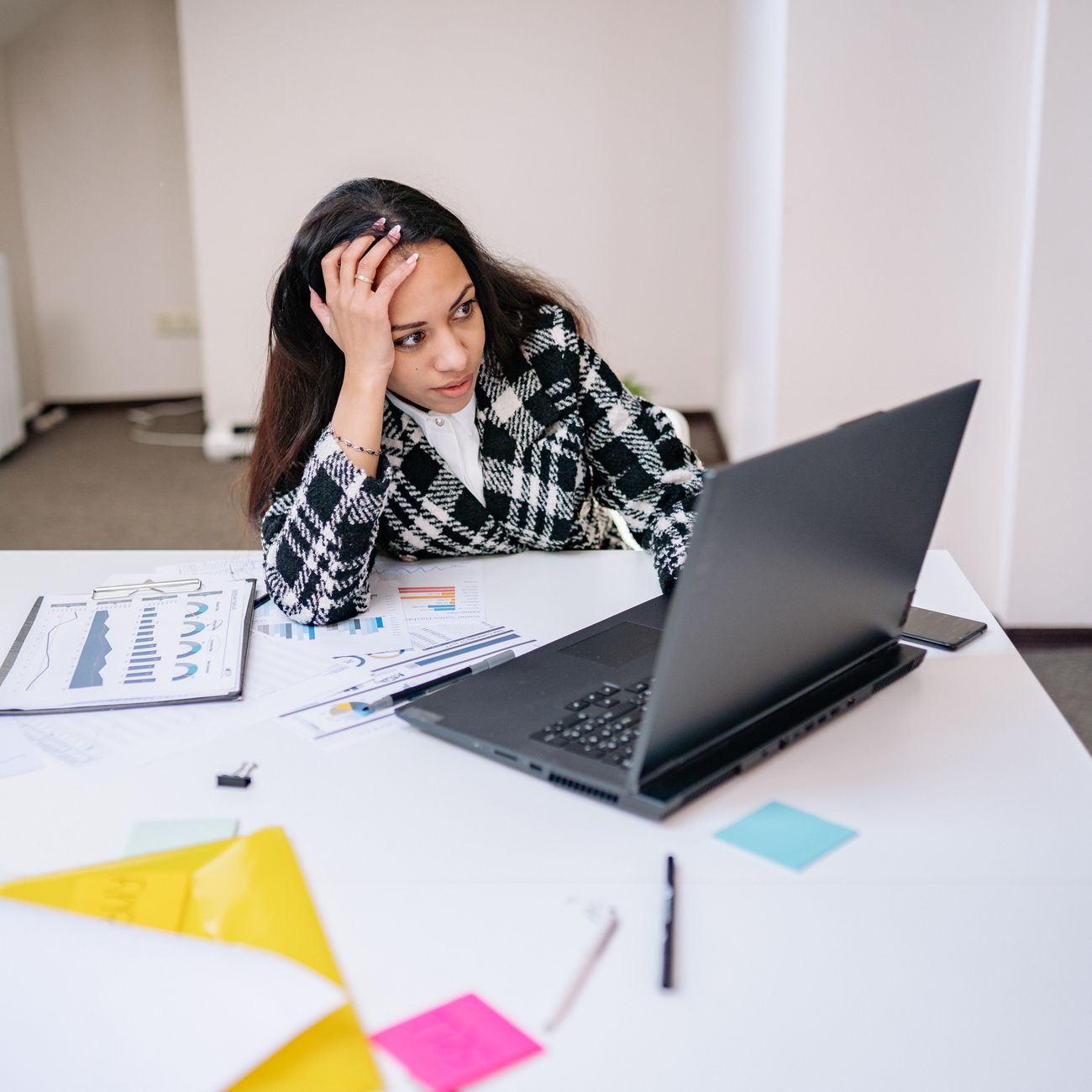 Person working through paperwork beside a laptop
