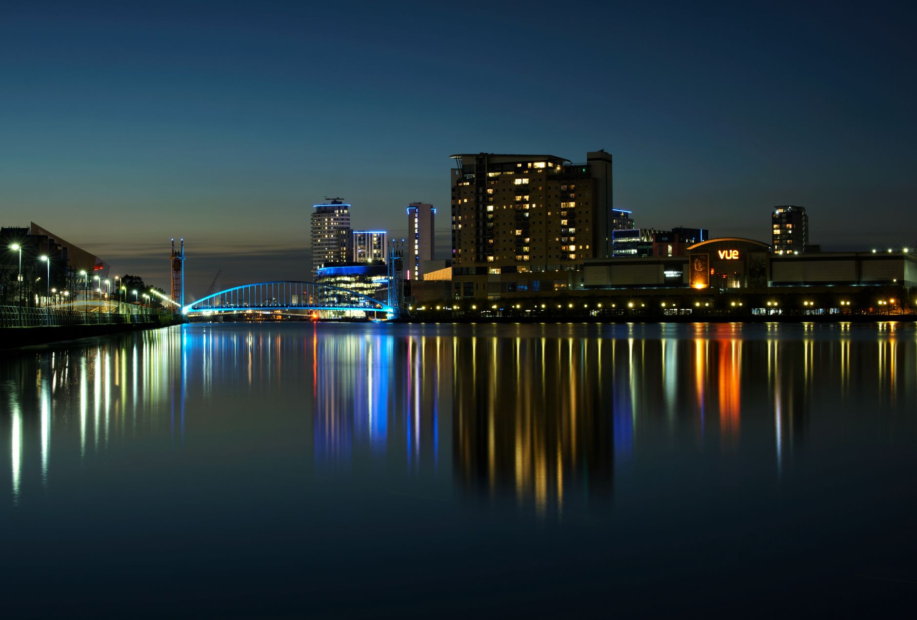 City buildings reflected in water at dusk